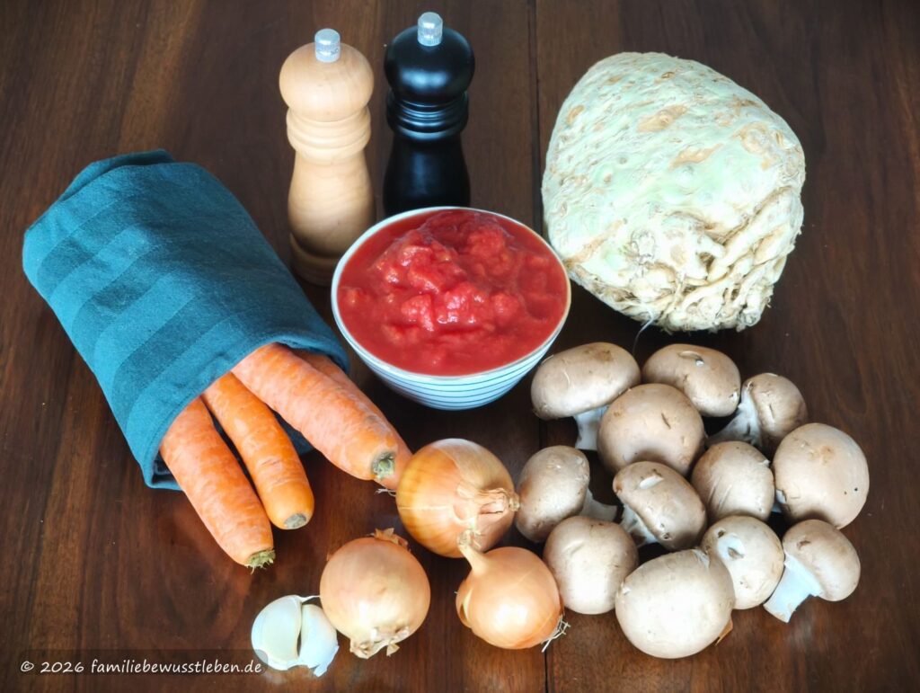 Zutaten für eine Gemüsebolognese: Möhren, Champignons, Sellerie, Zwiebeln, Knoblauch, stückige Tomaten aus der Dose sowie Salz und Pfeffer.